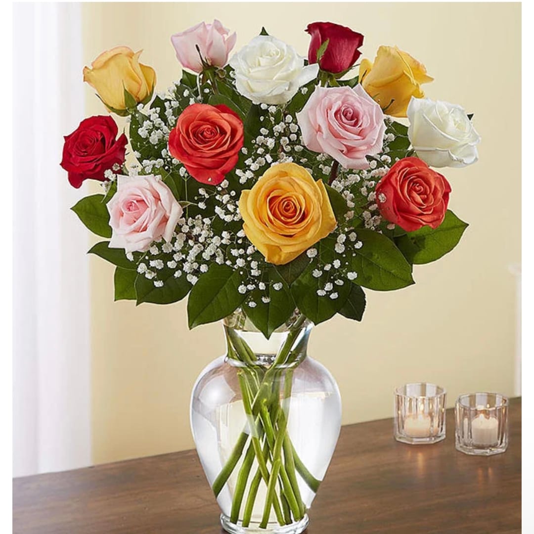 Mixed roses in a clear glass vase with baby's breath