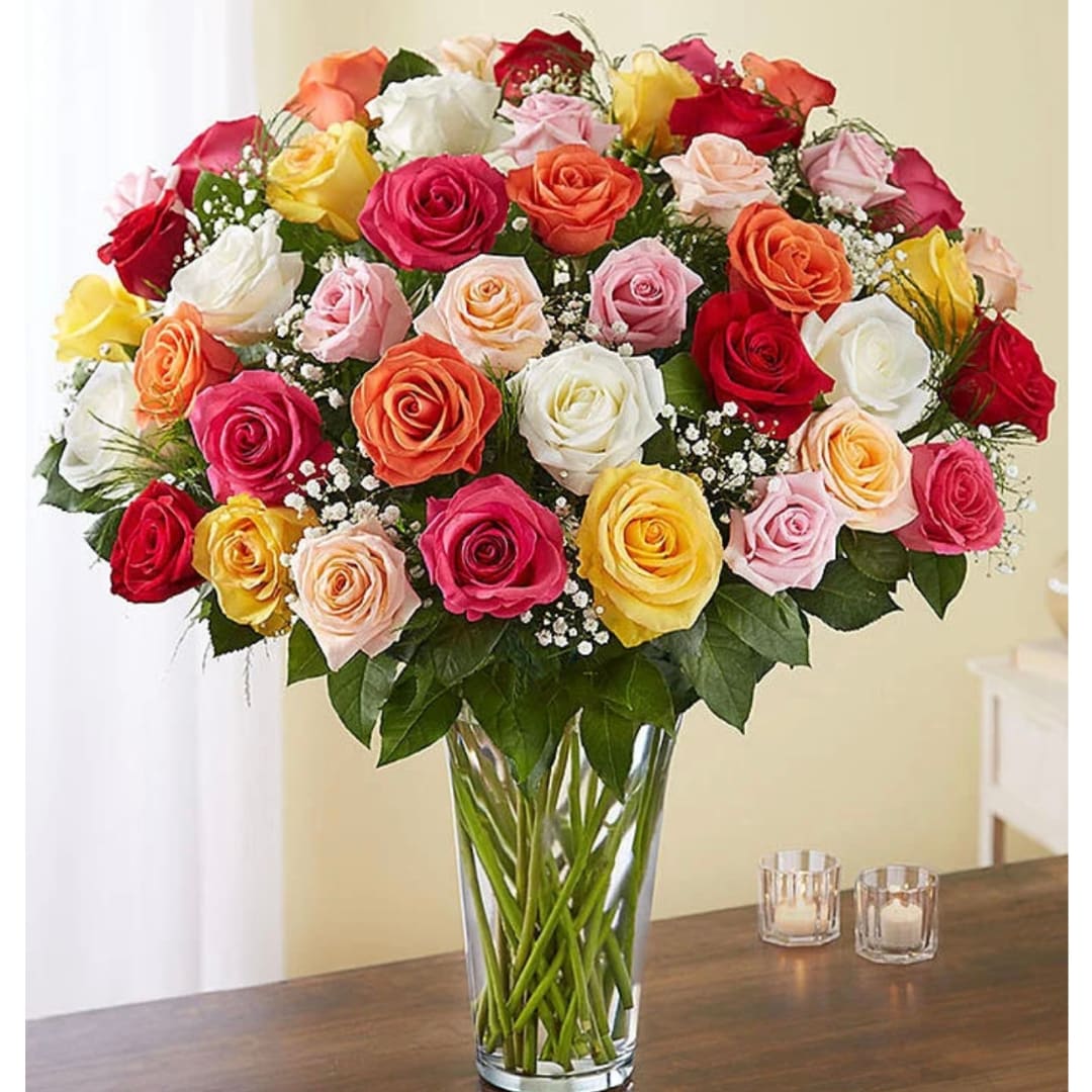 Mixed roses in a clear glass vase on a table