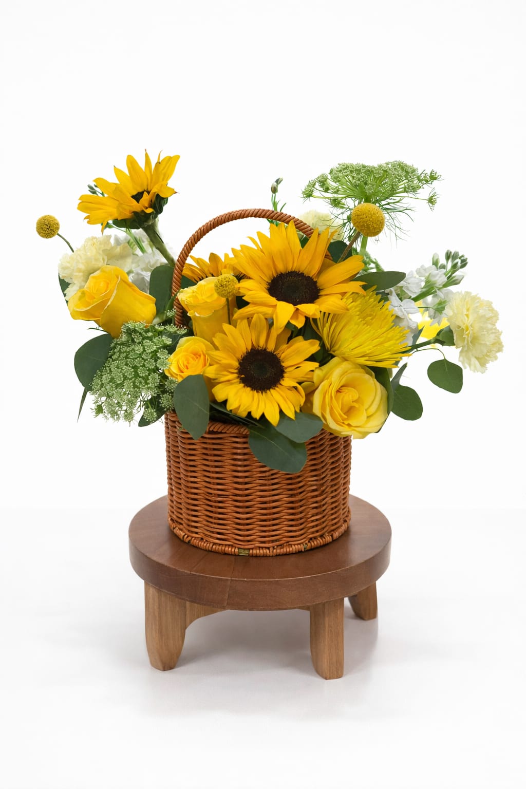 Yellow sunflowers and roses arranged in a wicker basket