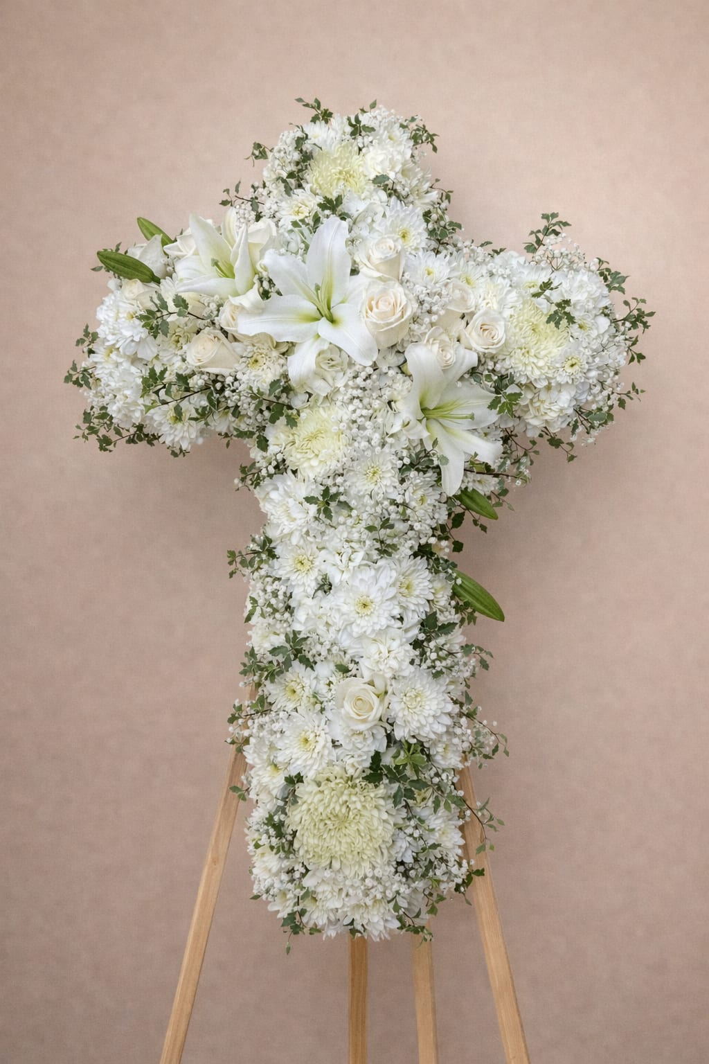 White floral cross arrangement on a wooden easel