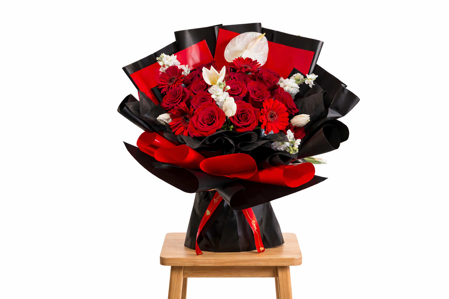 Bouquet of red roses with white flowers wrapped in black and red paper