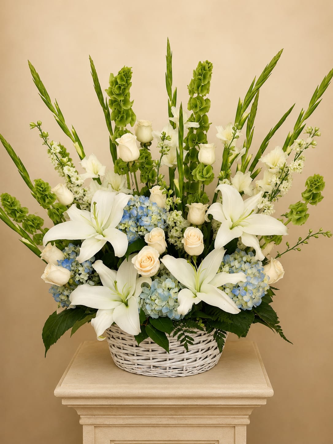 Peaceful Horizon  - A graceful standing basket featuring elegant white lilies, ivory roses, soft blue hydrangeas, gladiolus, bells of Ireland, and premium seasonal blooms. Designed to offer comfort, peace, and heartfelt remembrance