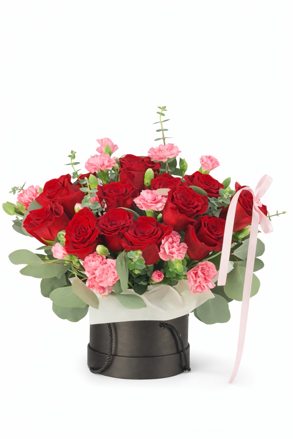 Red roses and pink carnations in a black hatbox with a pink ribbon