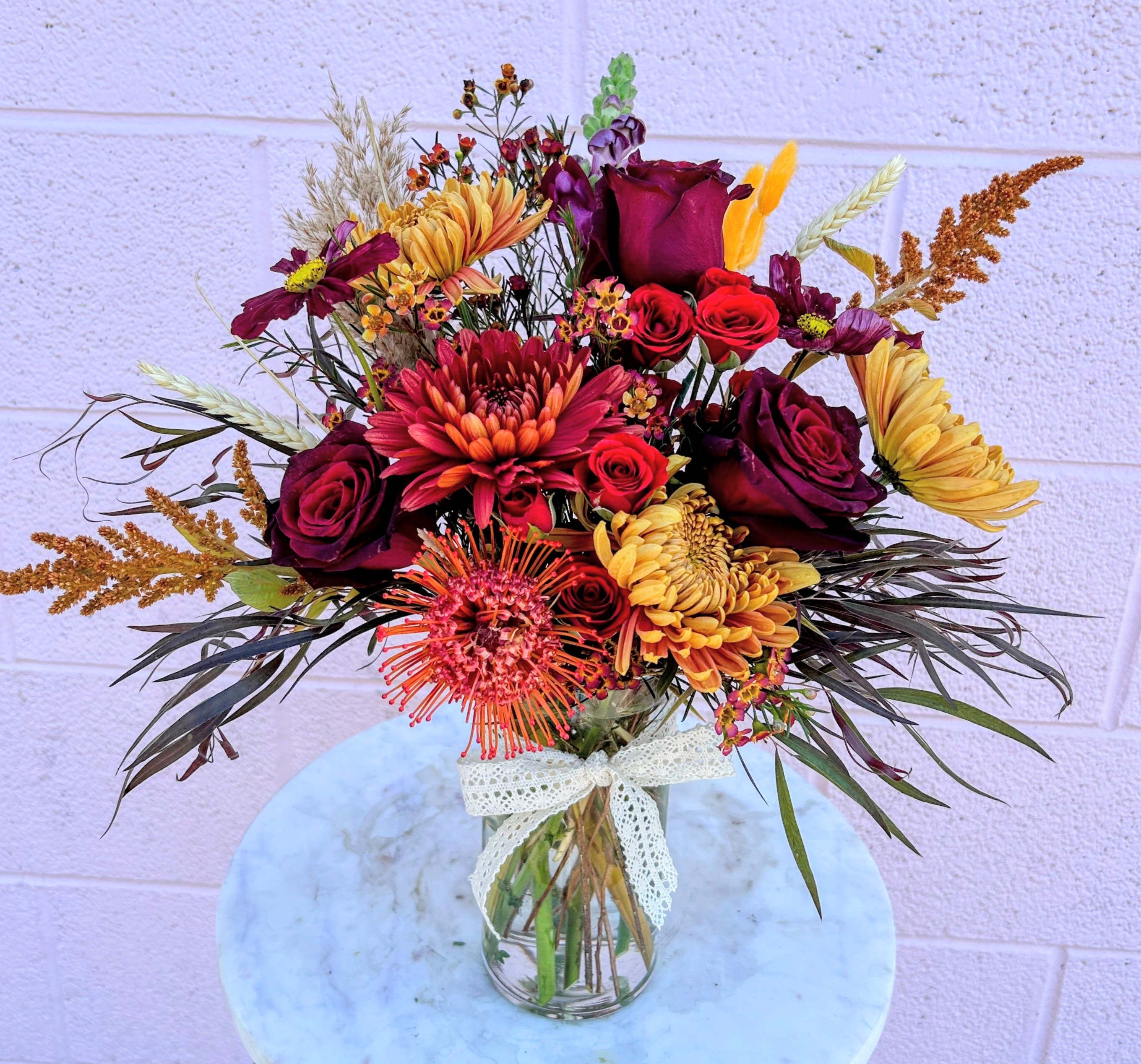 Autumn Harvest Bouquet - Embrace the rich, vibrant hues of fall with our Autumn Havest Bouquet. This enchanting arrangement features an elegant mix of deep crimson, golden, and orange hues to represent the warm, inviting feeling of fall.  The specific flowers used in each bouquet will vary as we hand-pick flowers based on freshness and seasonality. 