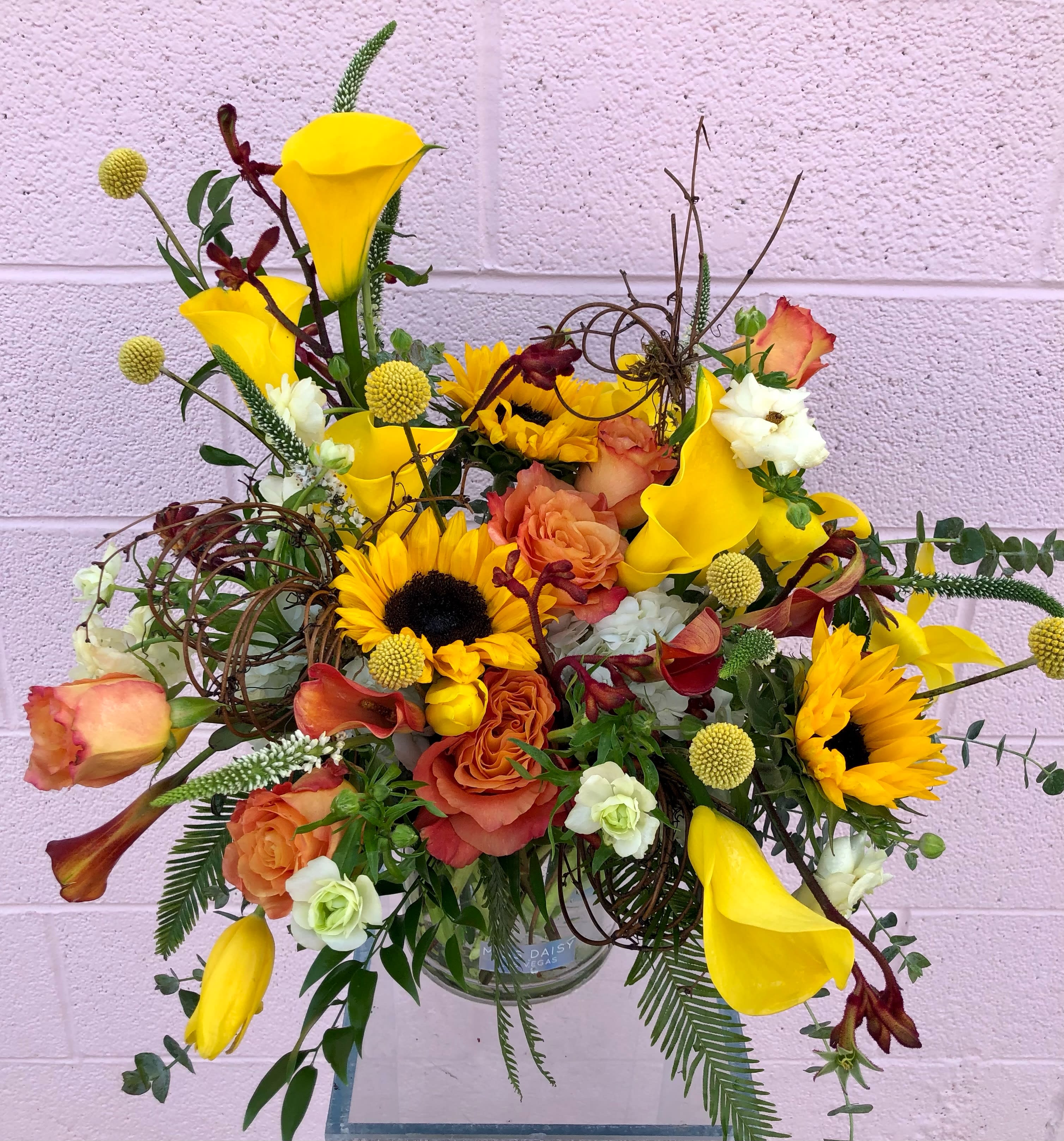 Mock be a Lady - Who's ready for cooler temps and autumn colors? We sure are! This arrangement has all the feels with beautiful sunflowers, calla lilies, roses, hydrangea and other beautifully toned elements.  It's possible that some days we may not have the exact flowers depending on the season, or exact container specified on the arrangement's description. When this is the case, our bouquets are made with flower substitutions or delivered in a different vase than expected by using substitutions of an equal or higher value. If you'd prefer no substitutions, please send an email or call us after placing your order. Please give us at least three days notice if you're looking for an arrangement with no substitutions.
