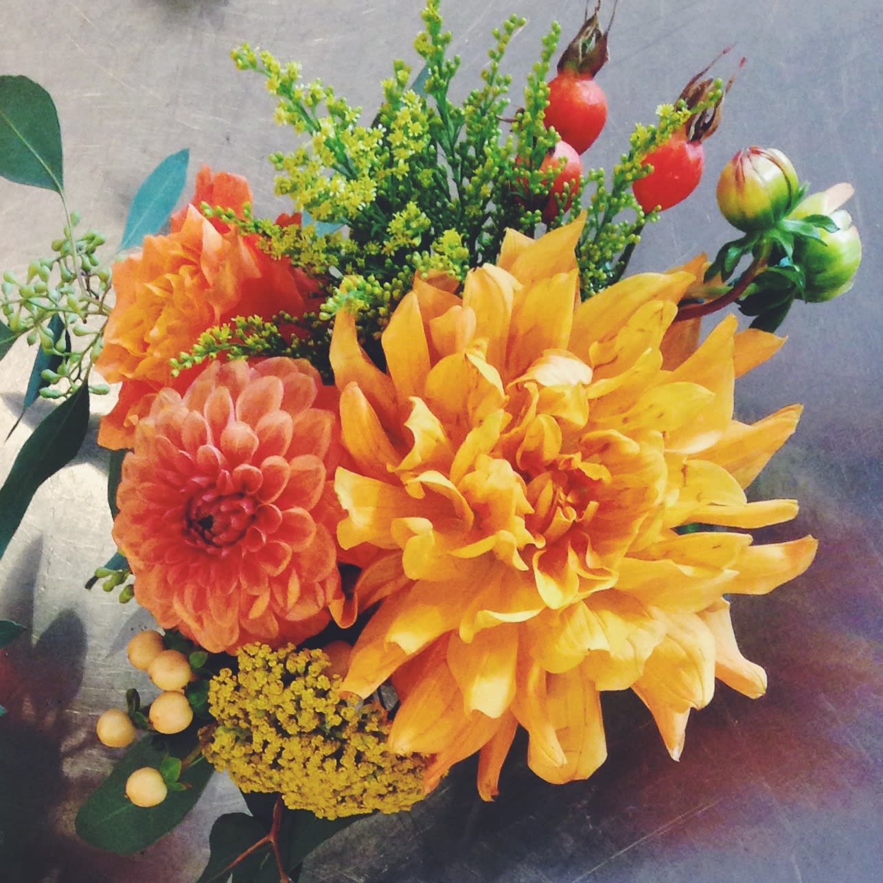 Bouquet of orange and yellow dahlias with red berries