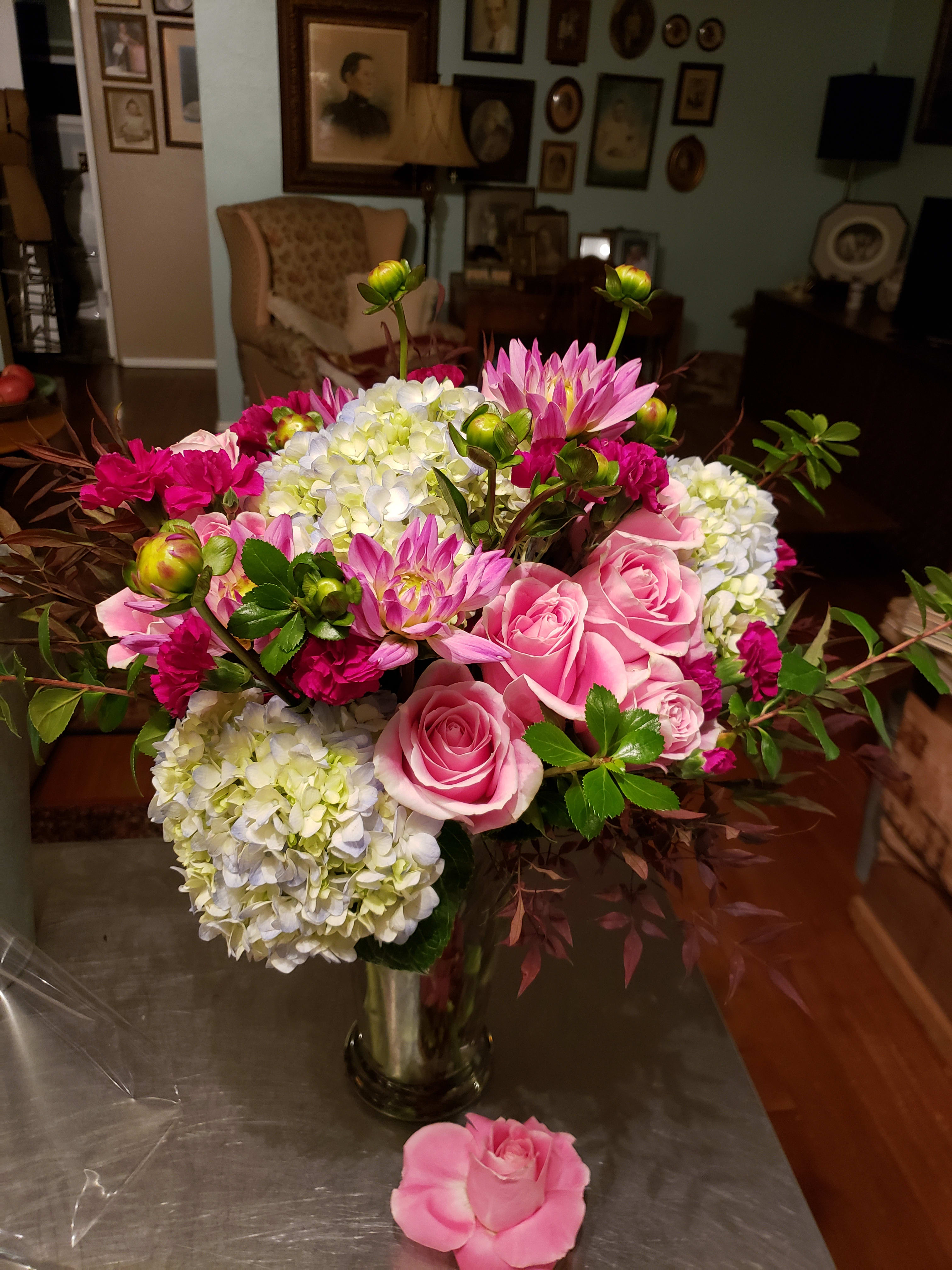 Pink roses and hydrangeas in a glass vase with magenta blooms