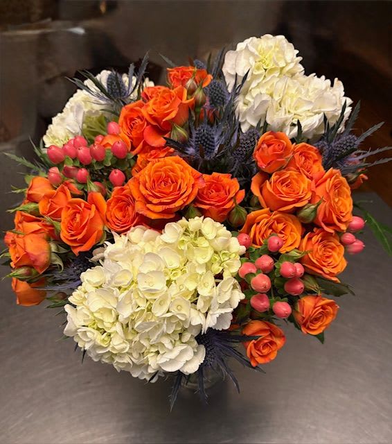 Bouquet of orange roses and white hydrangeas with pink berries
