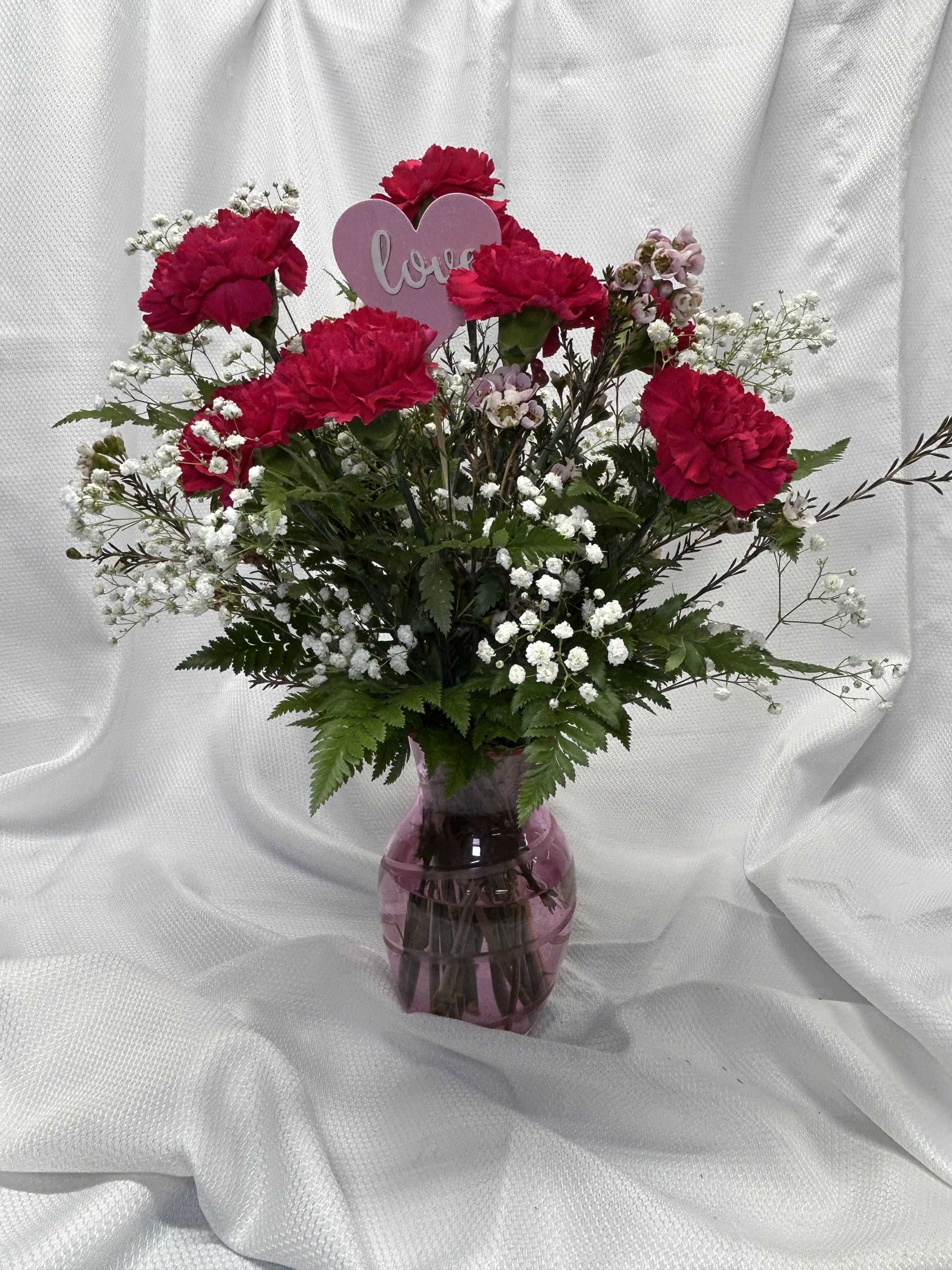 Honey Bunny - 12carnations arranged in a vase with babies breath and wax flower. Hot pink shown, please specify color: red, pink, white, hot pink, yellow, or mixed red, white &amp; pink.