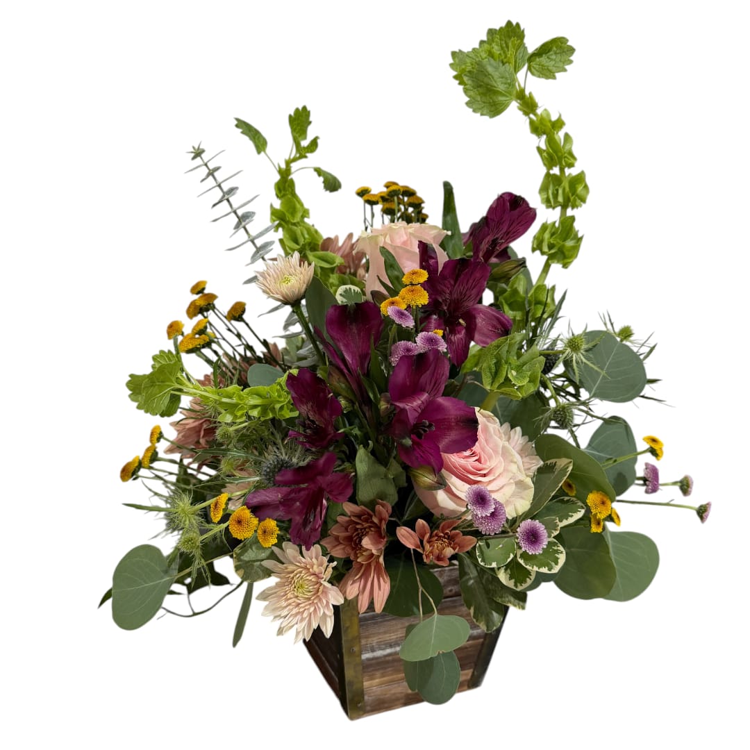 Mixed bouquet in a wooden container with purple and pink flowers