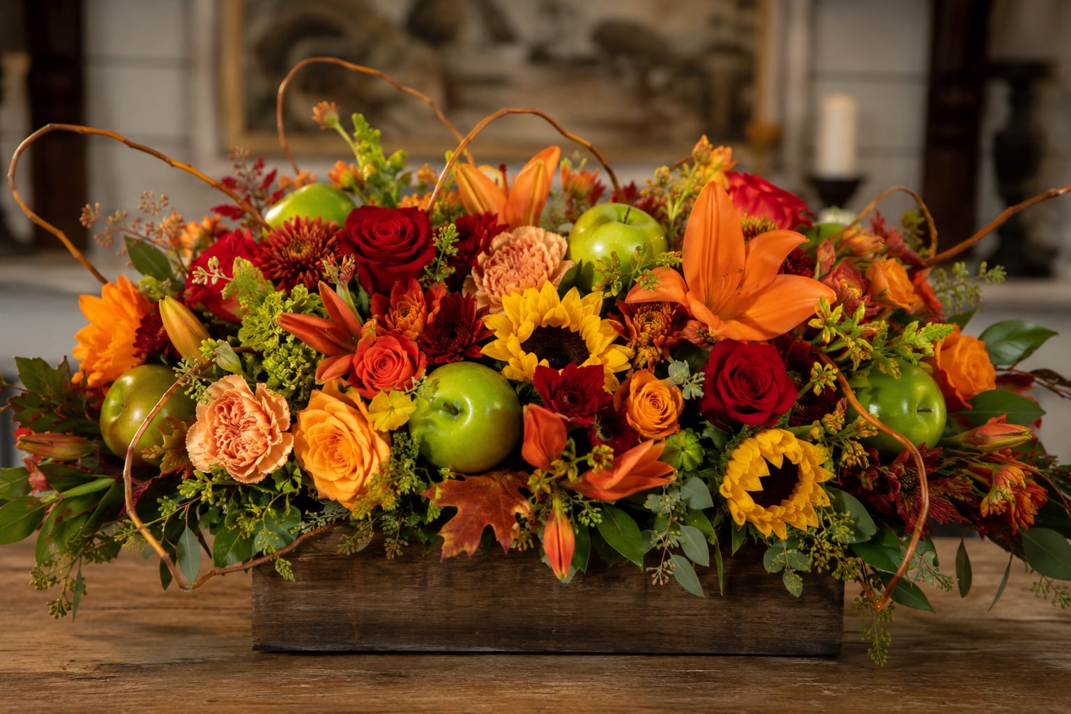 Autumn floral centerpiece with sunflowers, roses, lilies, and green apples in a wooden box