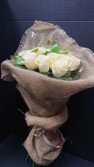 Bouquet of white roses wrapped in burlap