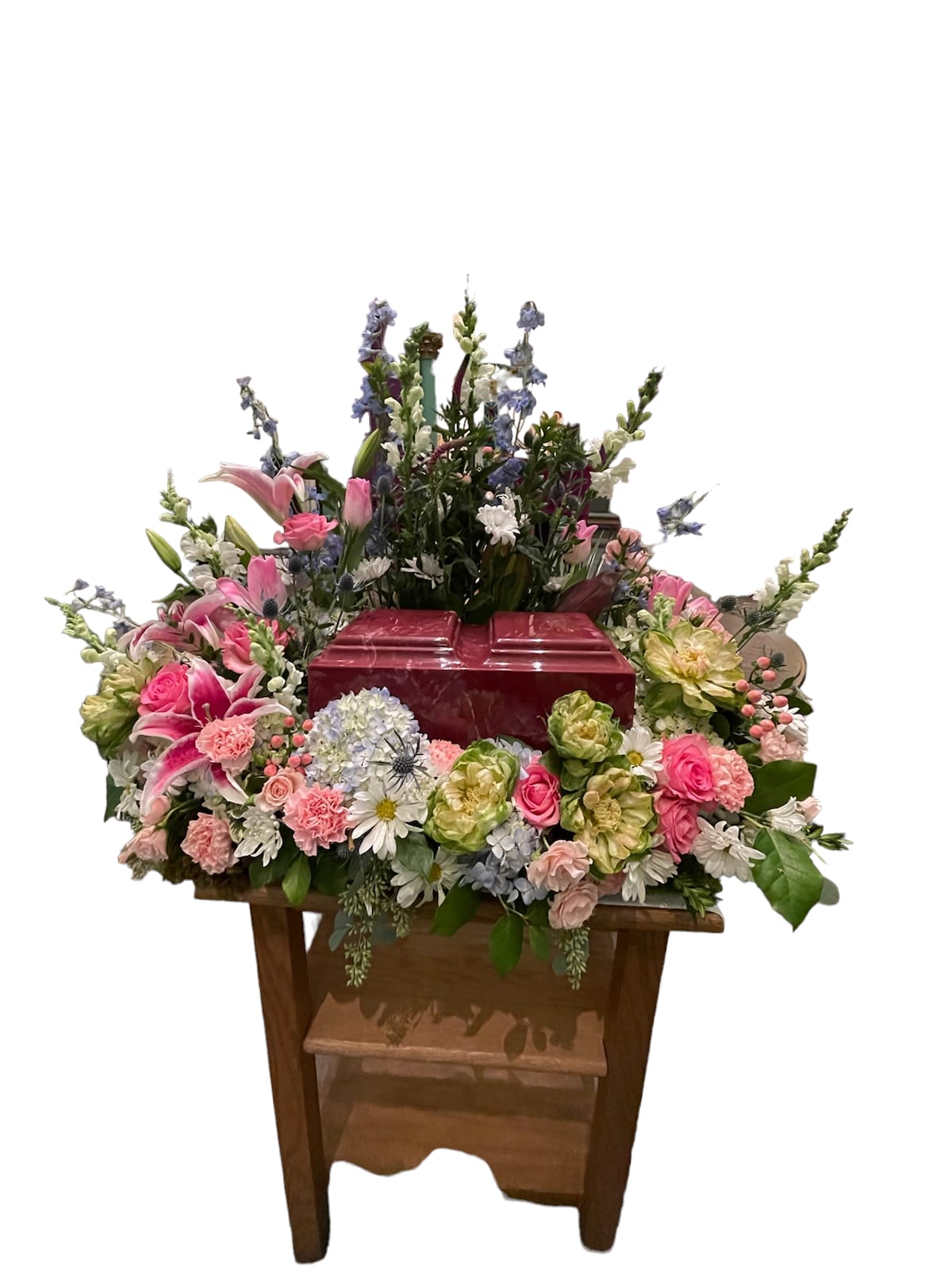 Large floral arrangement around a red casket
