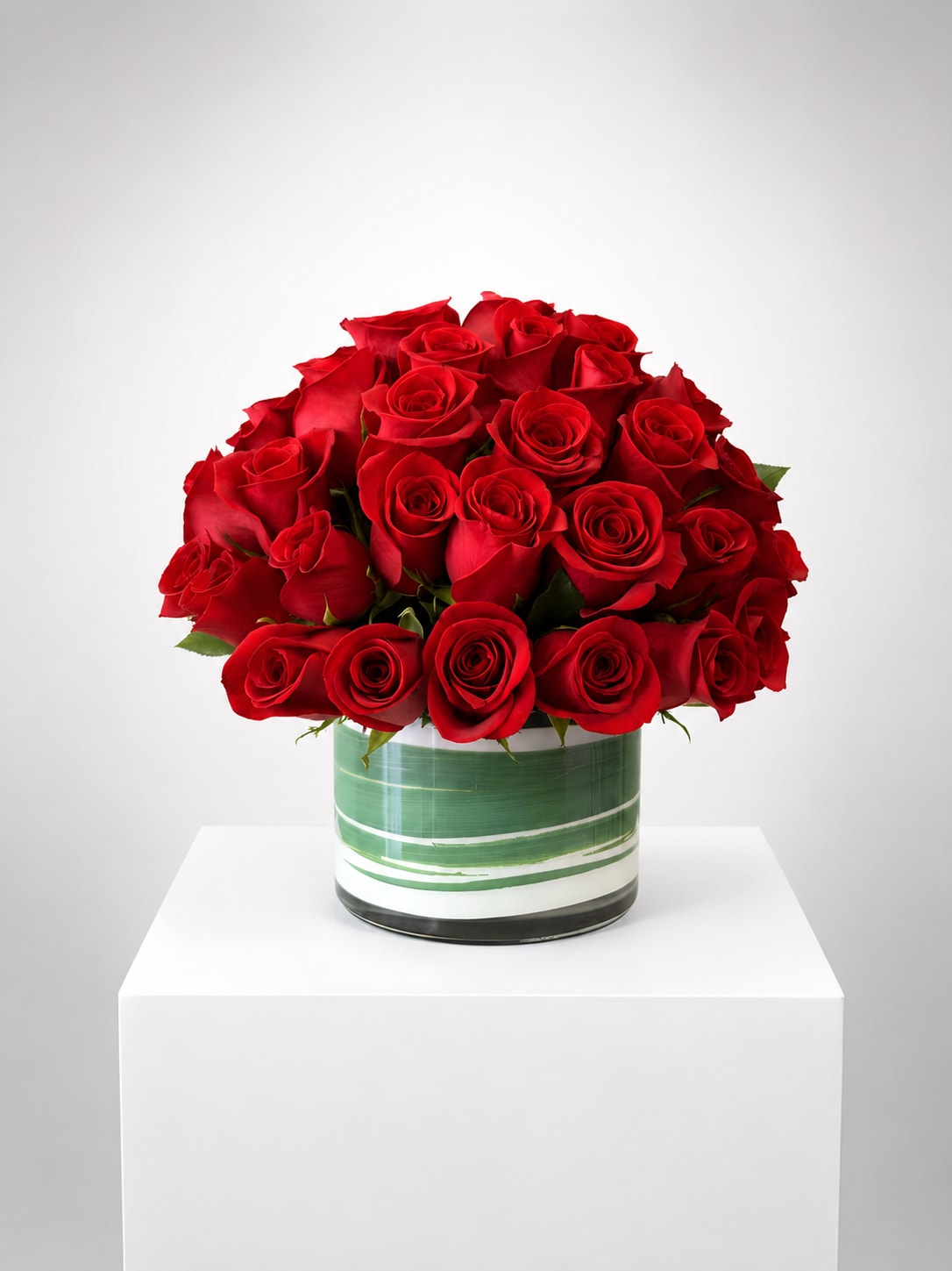 Red rose bouquet in a striped glass vase