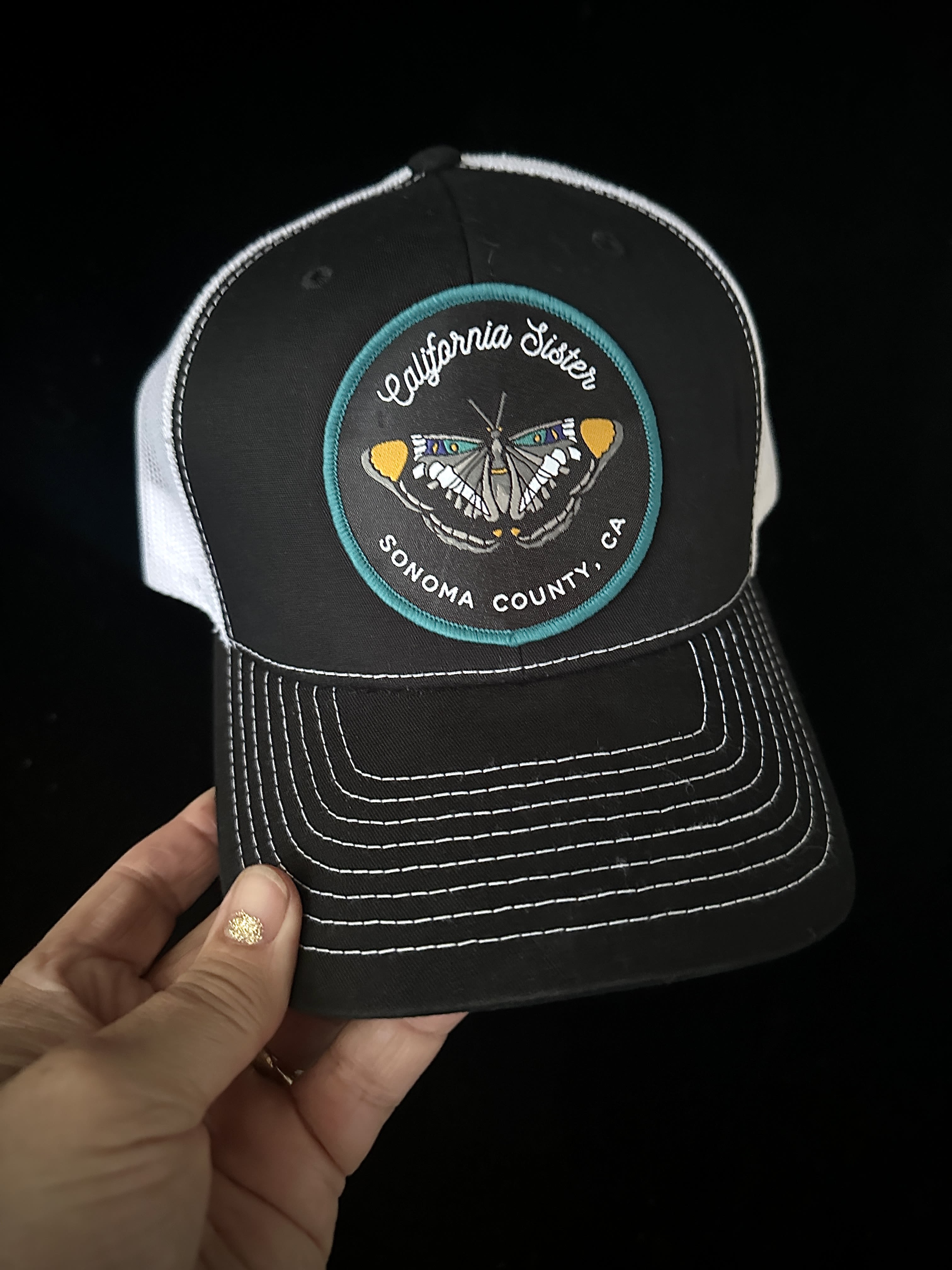 California Sister Trucker Hat - California Sister patch on a white mesh Trucker  ball cap. SnapBack, and contrast stitching on the bill. Great for everyday wear! 