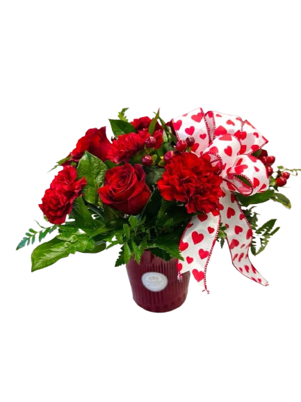 Red roses and carnations in a vase with a heart-patterned ribbon