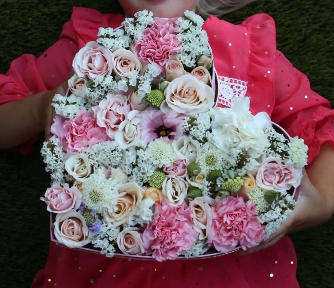Round bouquet of pink and cream roses with carnations and white filler flowers