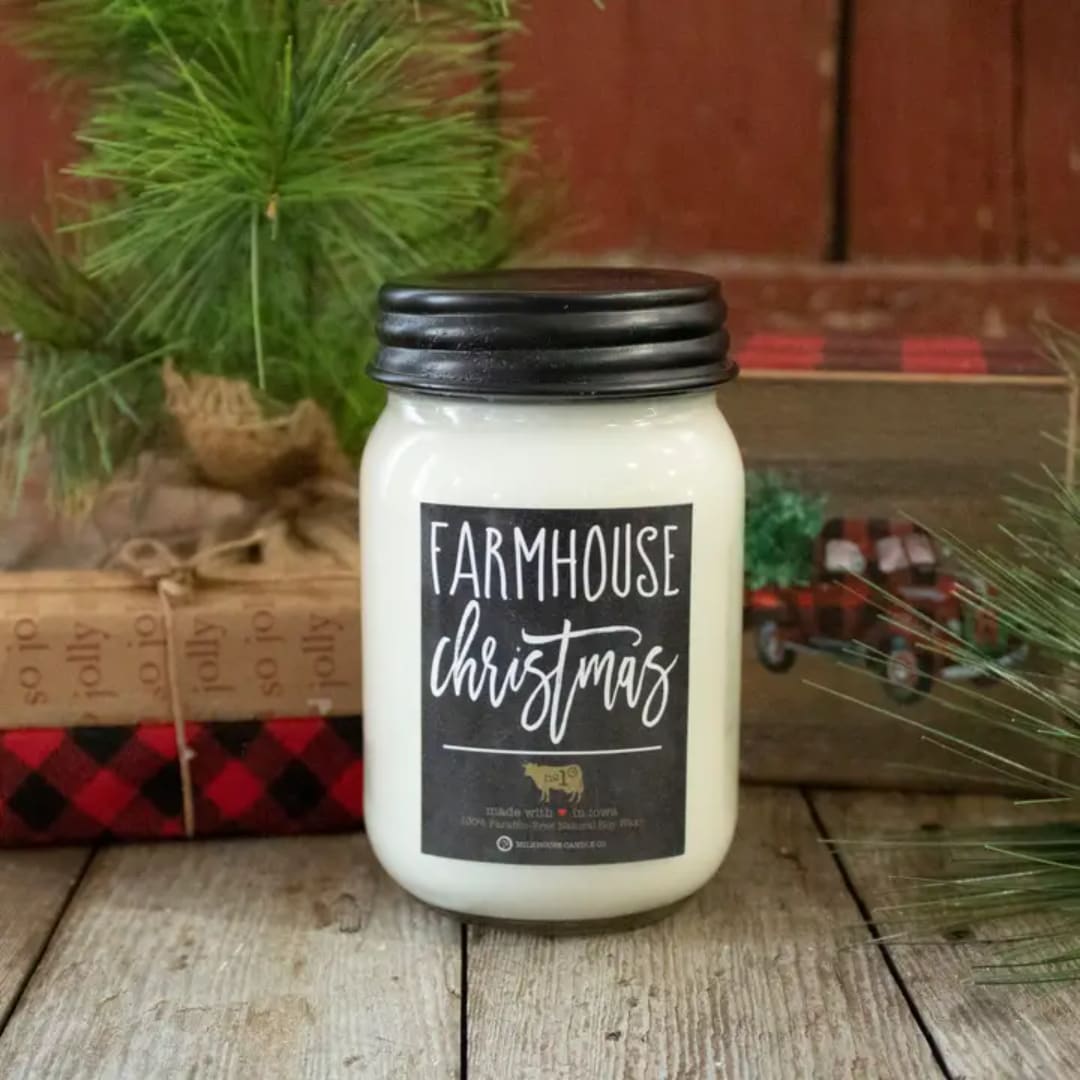 White jar candle with a black lid and Christmas label