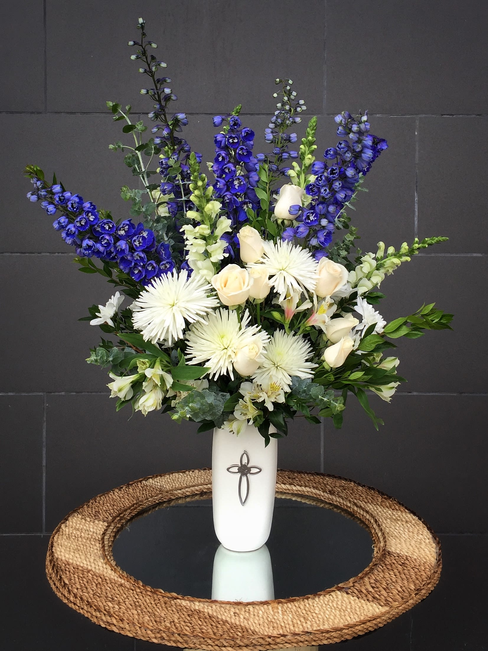 Tall white vase arrangement with blue and white flowers