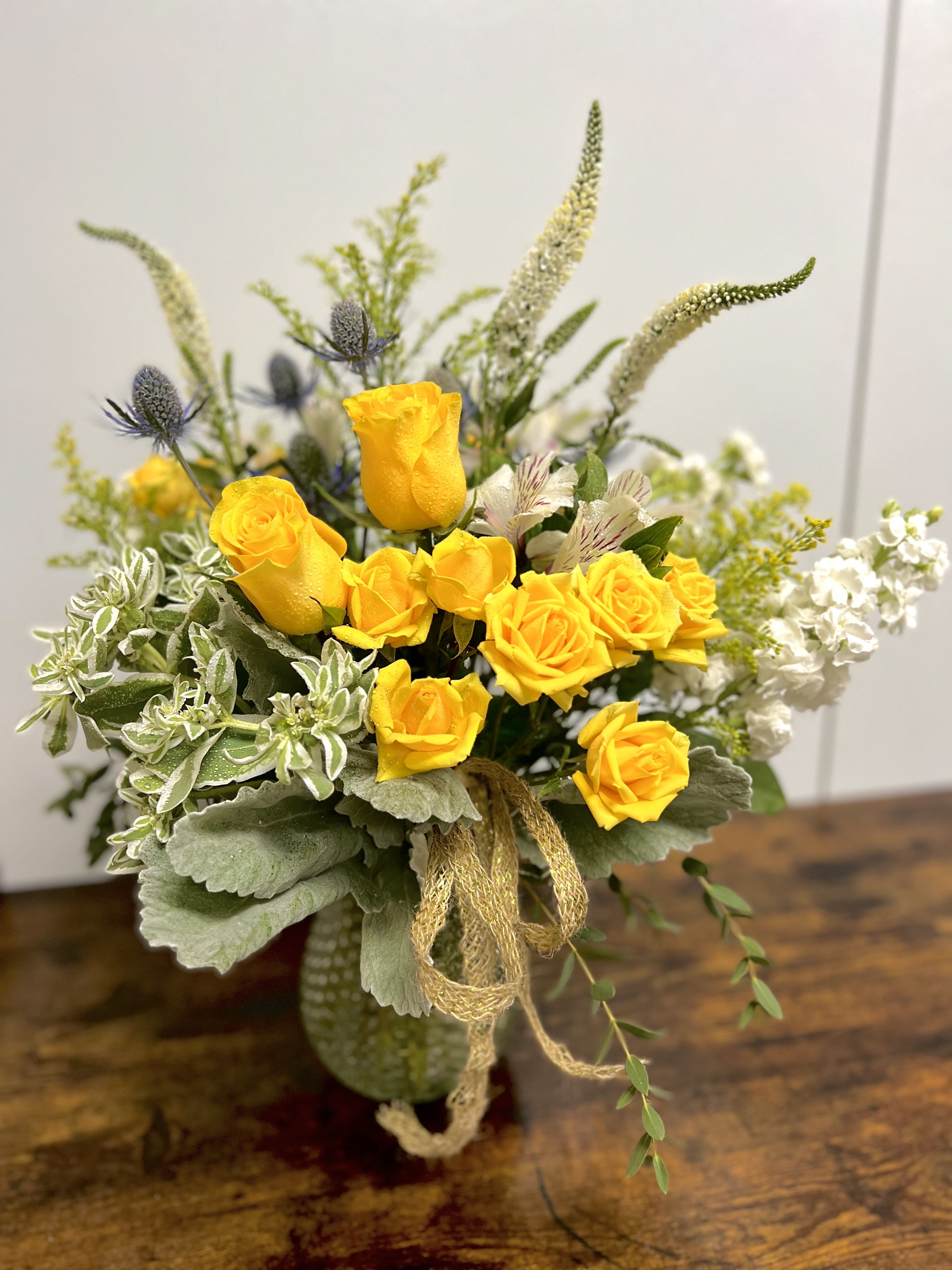 Yellow roses in a vase with white and green accents