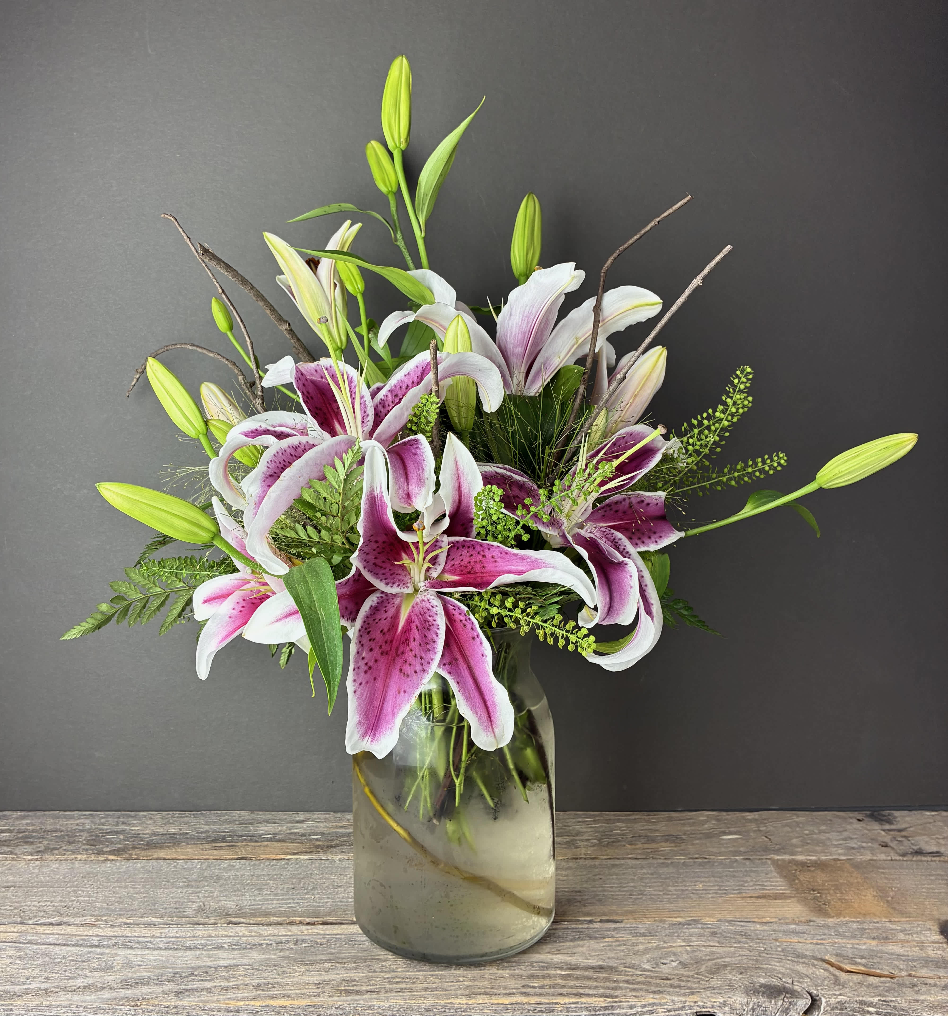 Pink and white lilies arranged in a glass vase