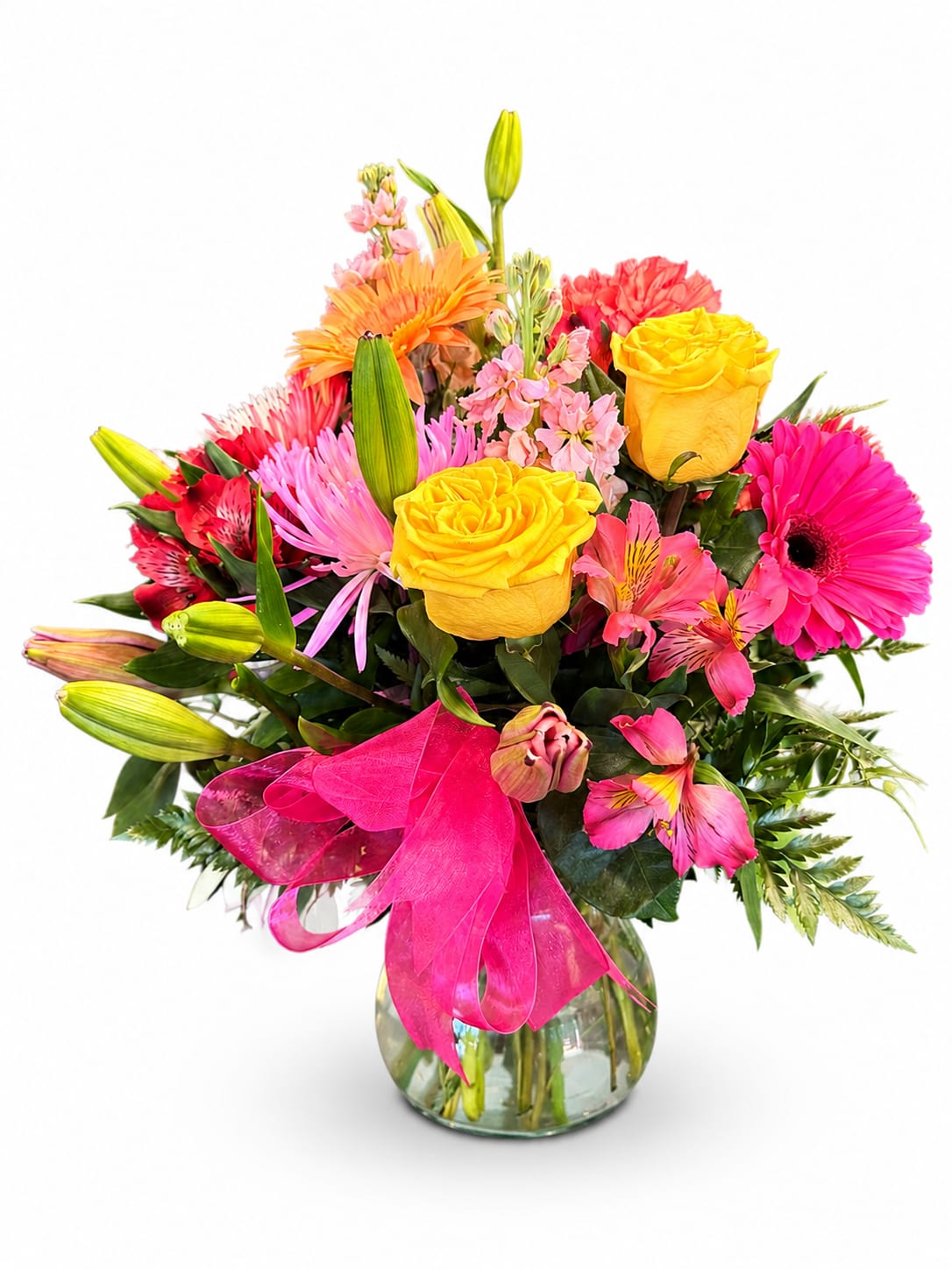 Bright mixed bouquet with yellow roses, pink gerberas, and lilies in a glass vase