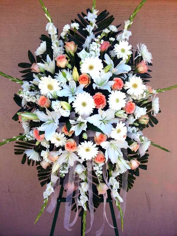 Standing floral spray with white lilies, daisies, and peach roses