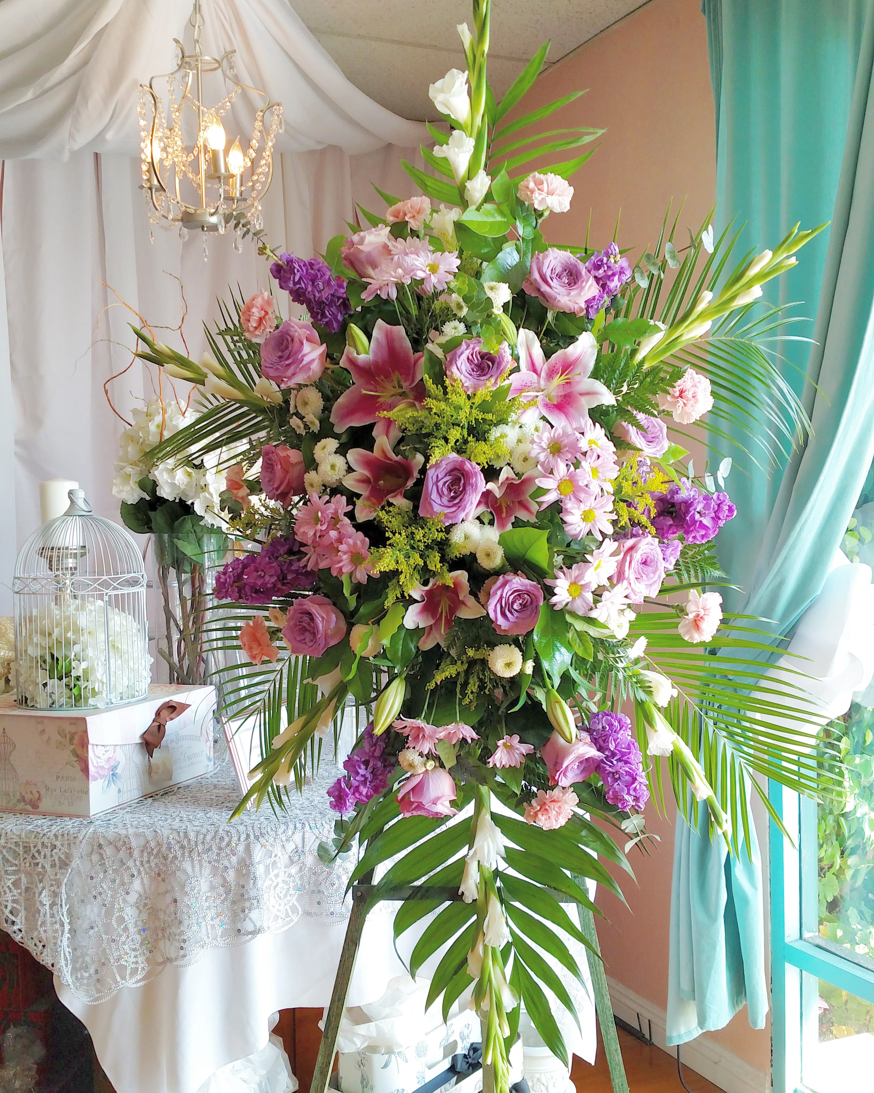 Large pink and purple floral arrangement on a stand