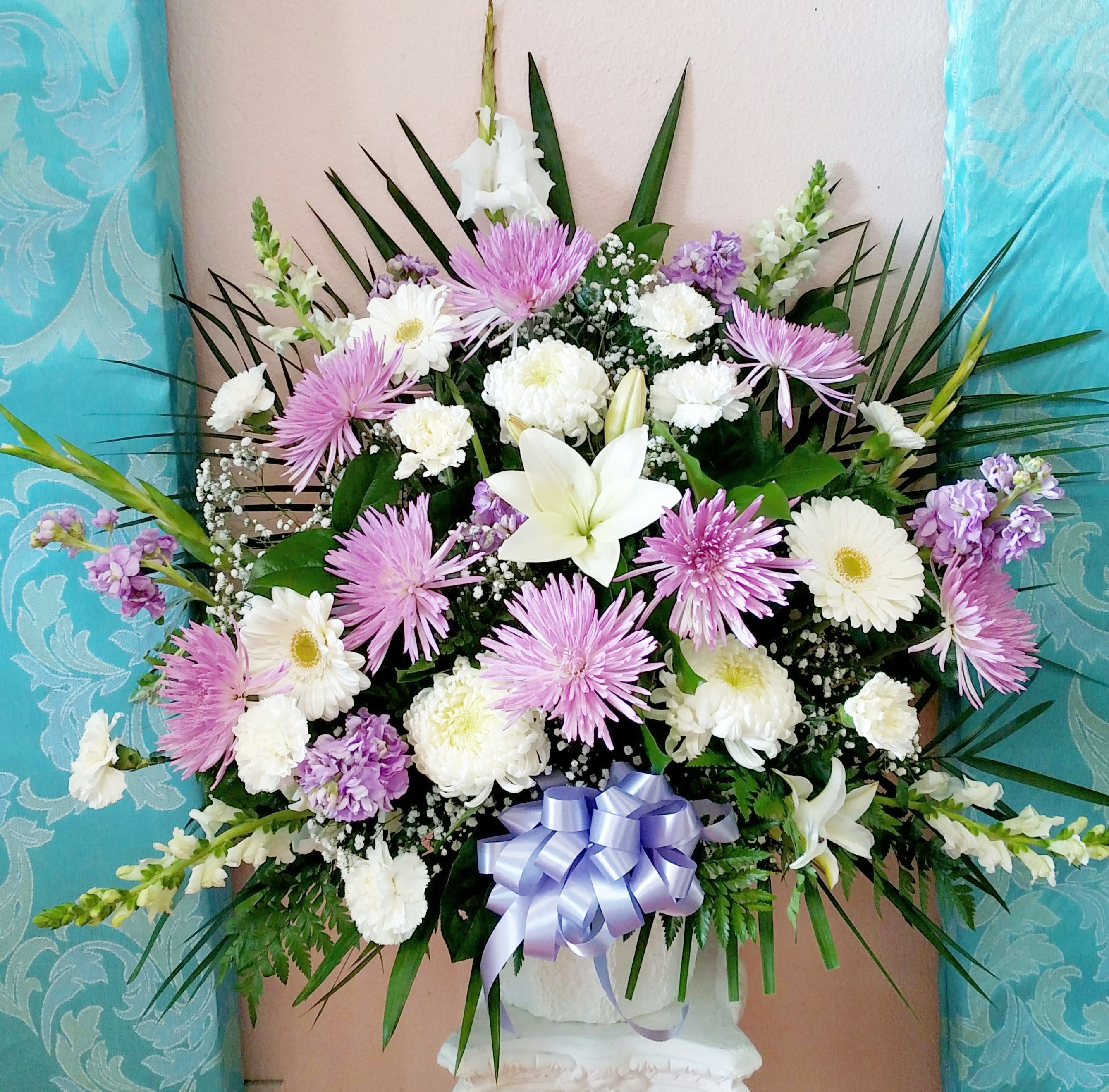 Large bouquet of white and lavender flowers with a ribbon bow