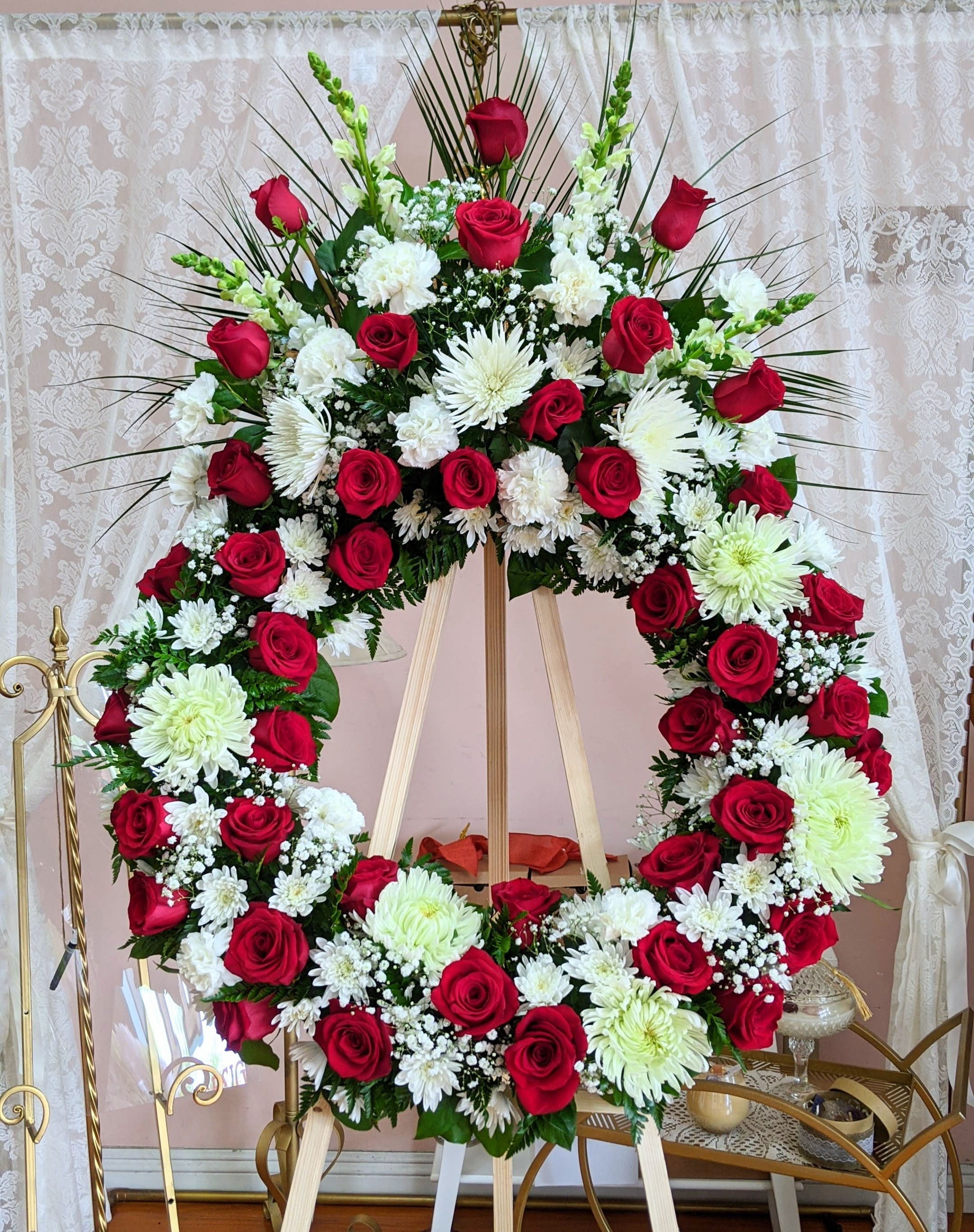 Large red and white floral wreath on an easel