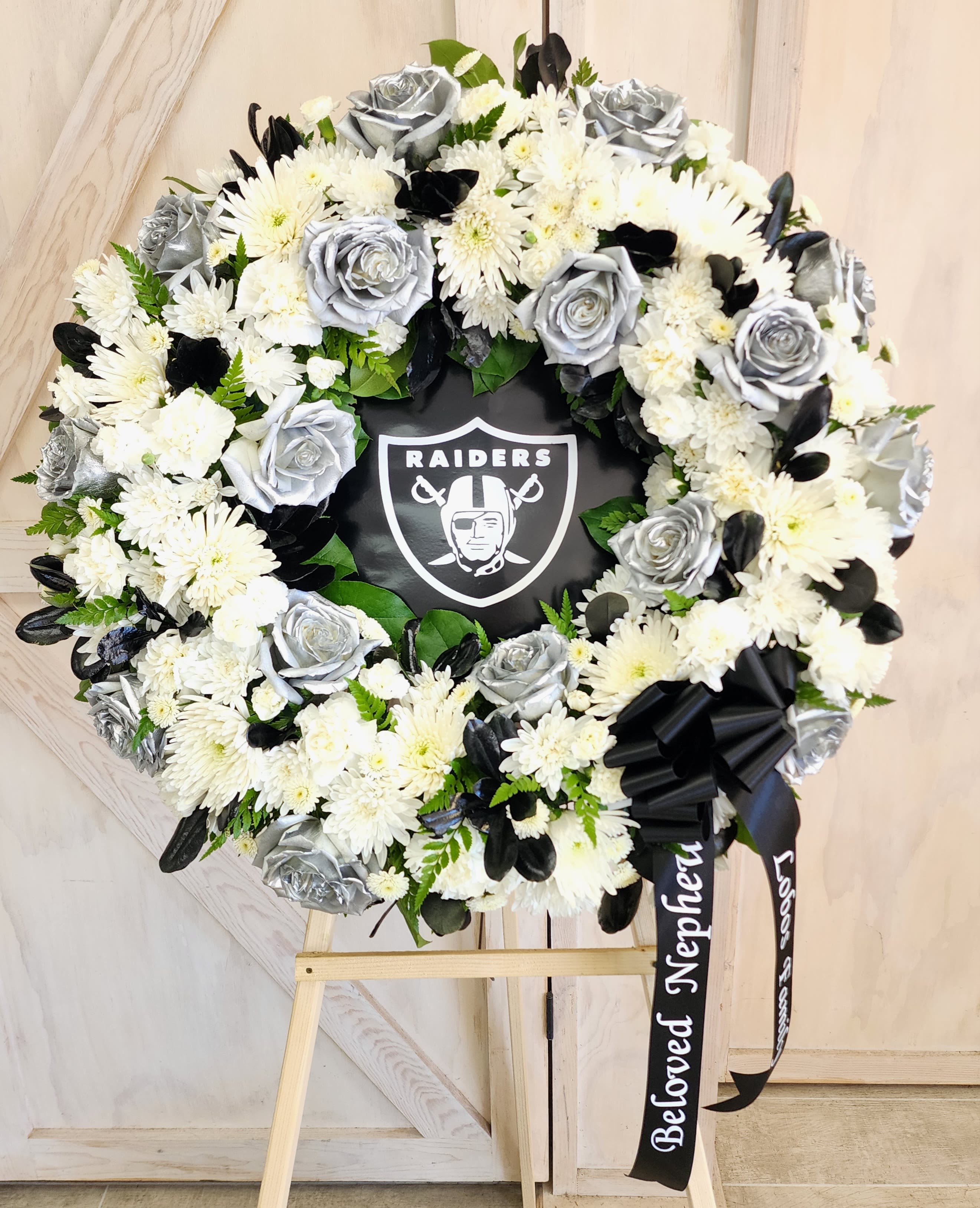 Black and white floral wreath with a Raiders logo in the center