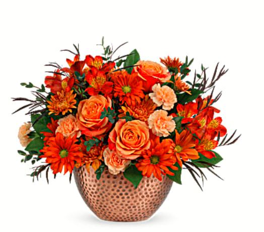 Copper Beauty Centerpiece - Capture the beauty of fall with the warm autumn hues of this lush rose bouquet, artfully arranged in a copper-finished keepsake bowl with timeless hammered detailing. Orange roses, red alstroemeria, miniature peach carnations and bronze cushion spray chrysanthemums are arranged with lemon leaf, parvifolia eucalyptus, and red agonis. Delivered in Teleflora's Copper Beauty bowl while supplies last. Orientation: All-Around