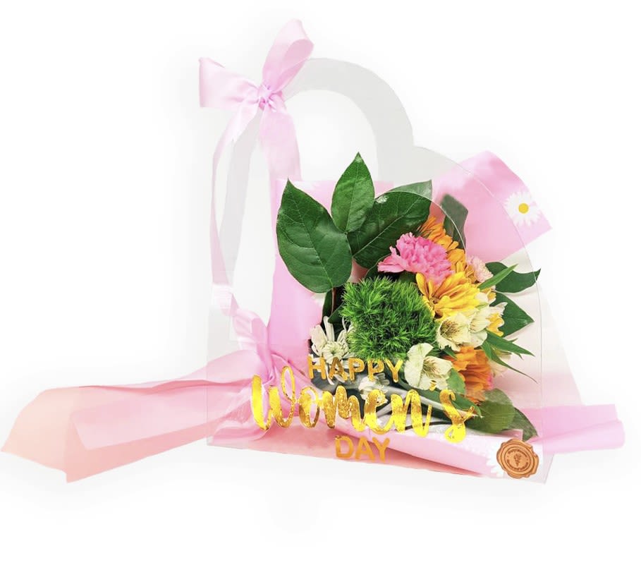 Pink and yellow flower bouquet in a clear gift bag with a "Happy Women's Day" sign