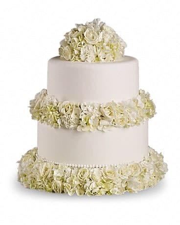 Three-tier white wedding cake with ivory floral garlands