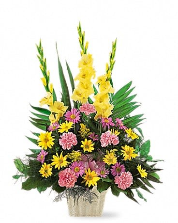 Tall floral arrangement with yellow gladiolus and pink and yellow daisies in a vase