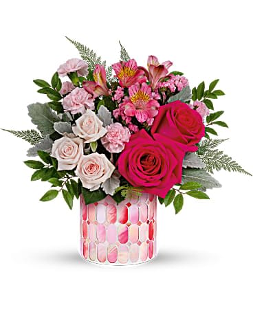 Pink and white rose bouquet in a patterned glass vase