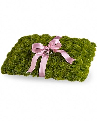 Green floral pillow tied with a pink ribbon