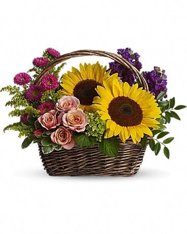 Basket arrangement with sunflowers, pink roses, and purple flowers