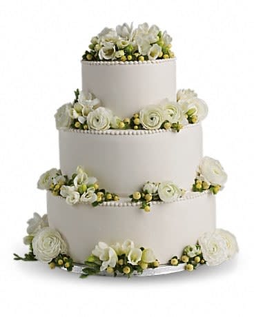 Four-tier white wedding cake with white flowers and yellow berries