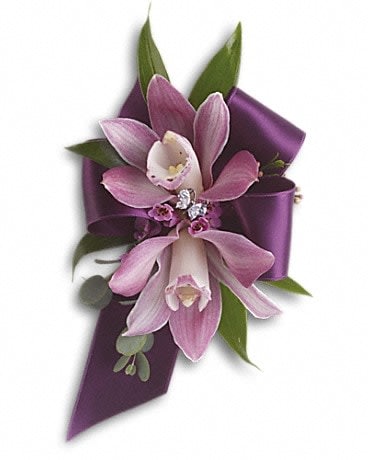Purple orchid corsage with ribbon and green leaves