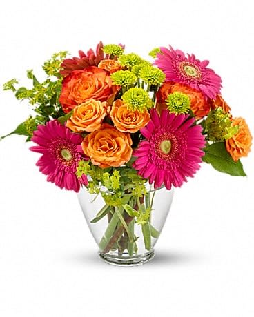Pink gerbera daisies and orange roses in a clear glass vase