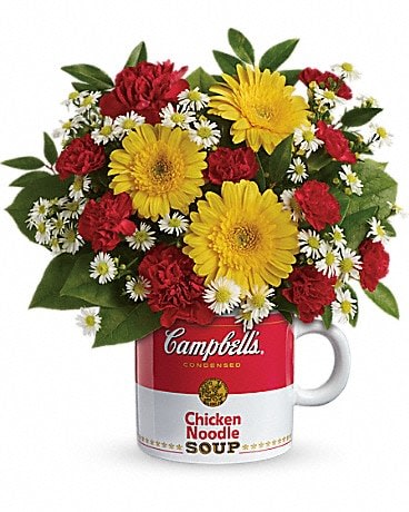 Bouquet of red and yellow flowers arranged in a Campbell's soup mug