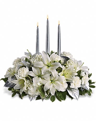 White floral centerpiece with three silver taper candles