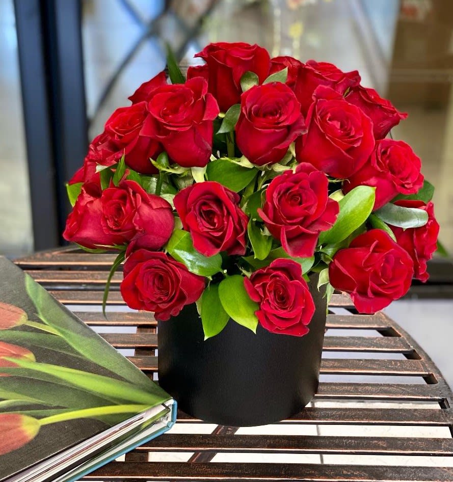 Red roses arranged in a black round box