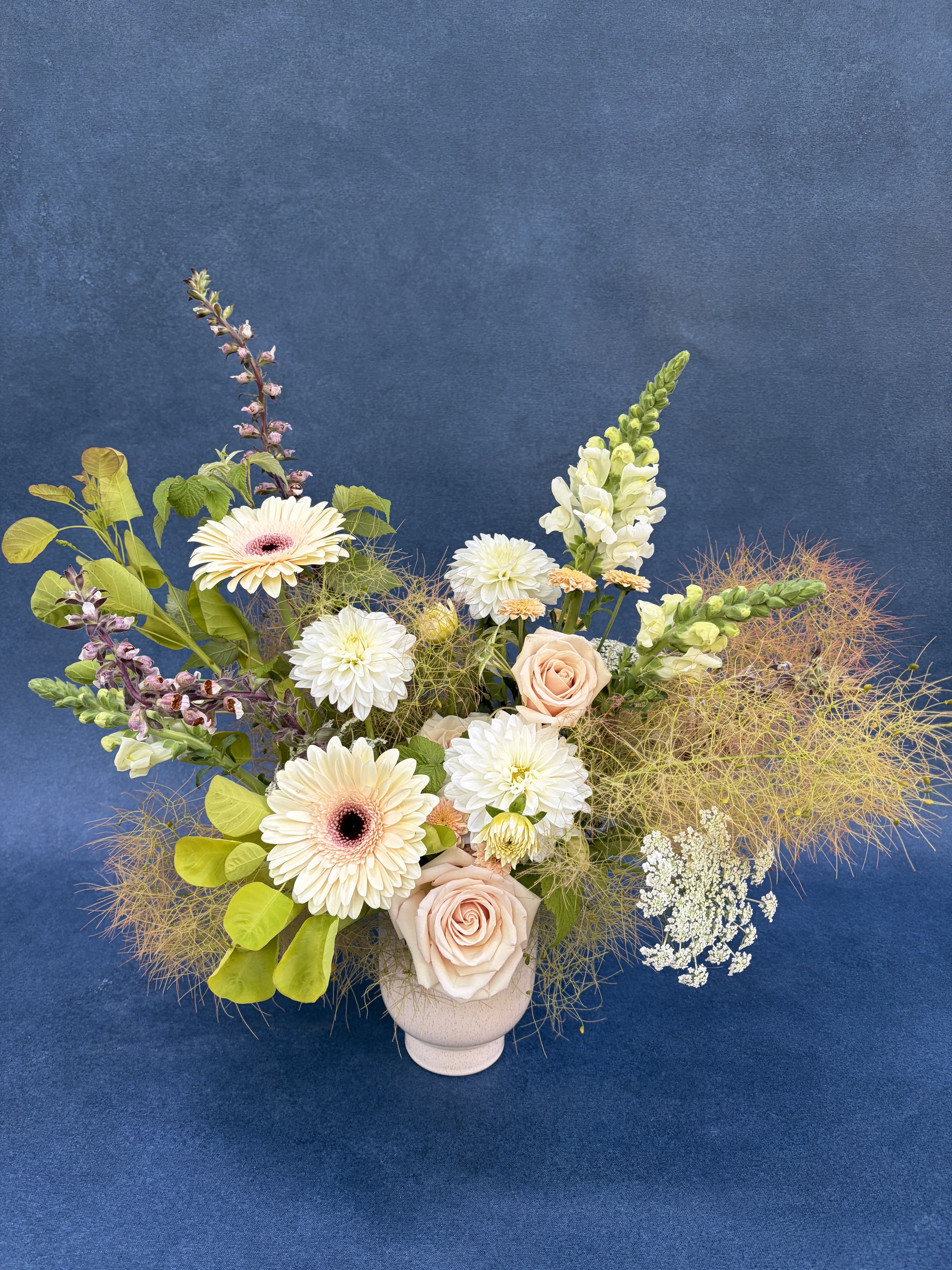 Designer's Choice - Soft &amp; Muted - **PICTURED IS A DELUXE **    Soft, muted tones make for a beautiful color palate any time of year.  PLEASE NOTE: Flower colors and varieties will vary due to availability. Our designers always select the freshest blooms for your arrangement.  Standard - 5" cream ceramic compote with a lush mix of seasonal blooms. Measures approximately 7"-8" tall and 7" wide.  Deluxe - 5" cream ceramic compote with a lush mix of seasonal blooms. Measures approximately 10" tall and 10" wide.  Premium - 5" cream ceramic compote a lush mix of seasonal blooms. Measures approximately 12" tall and 12" wide 