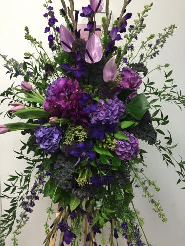 Tall purple floral spray with cascading greenery