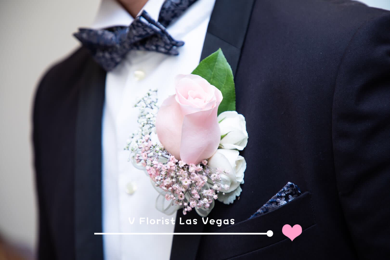 Pink and white boutonniere on a black suit jacket