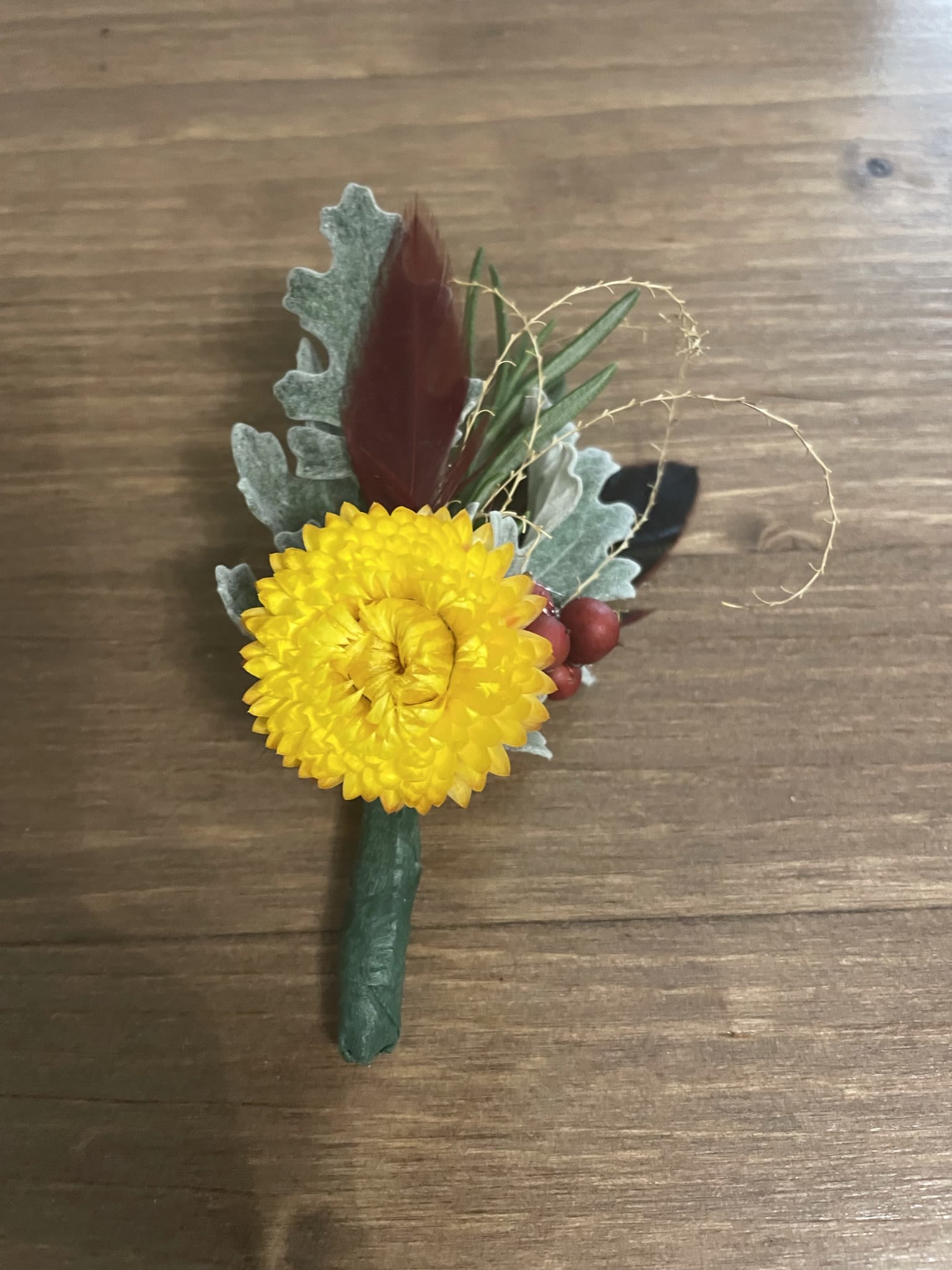 Yellow chrysanthemum boutonniere with berries and foliage