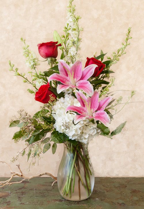 Pink lilies and red roses in a glass vase