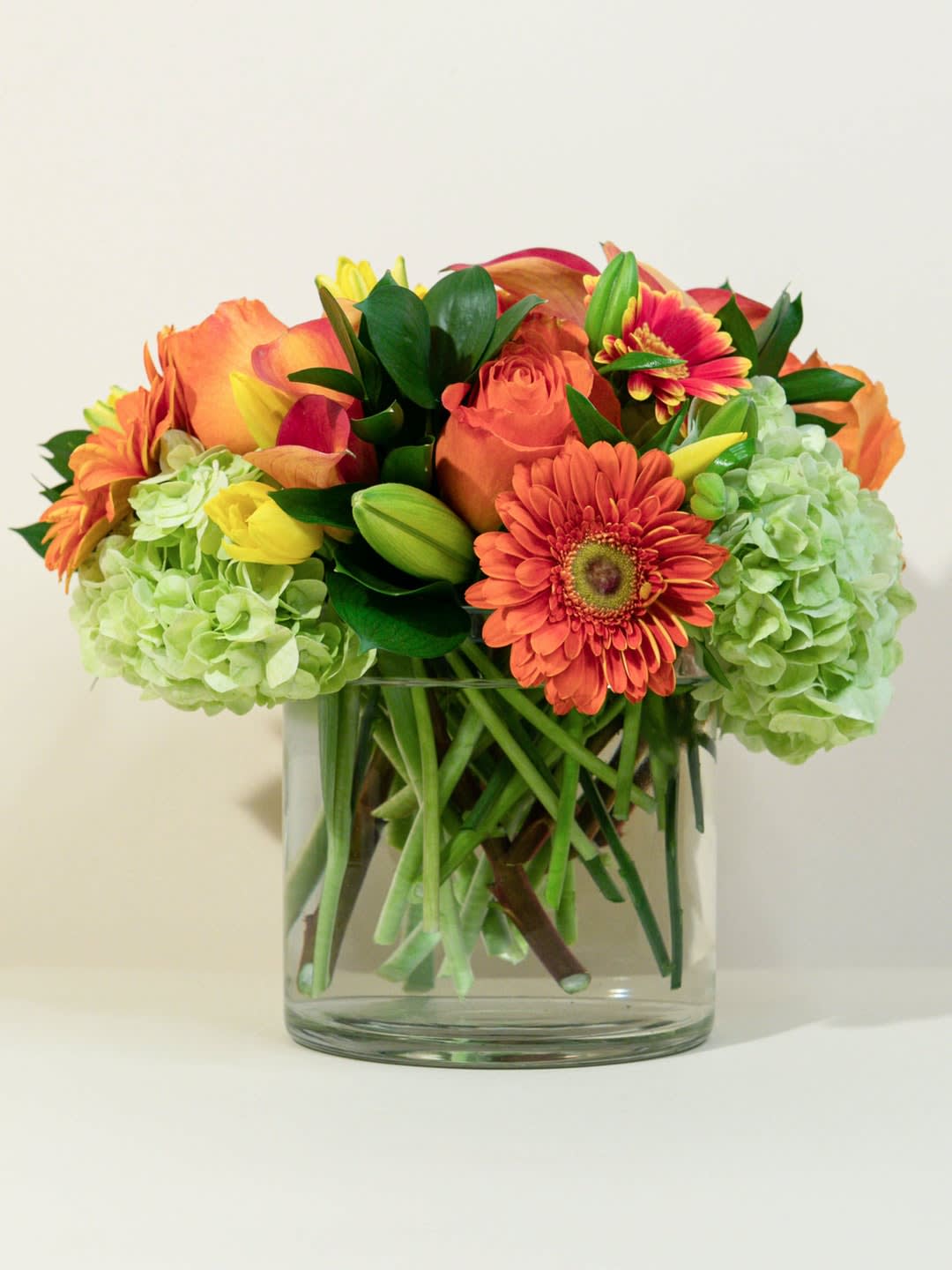 Orange and yellow mixed bouquet in a clear glass vase